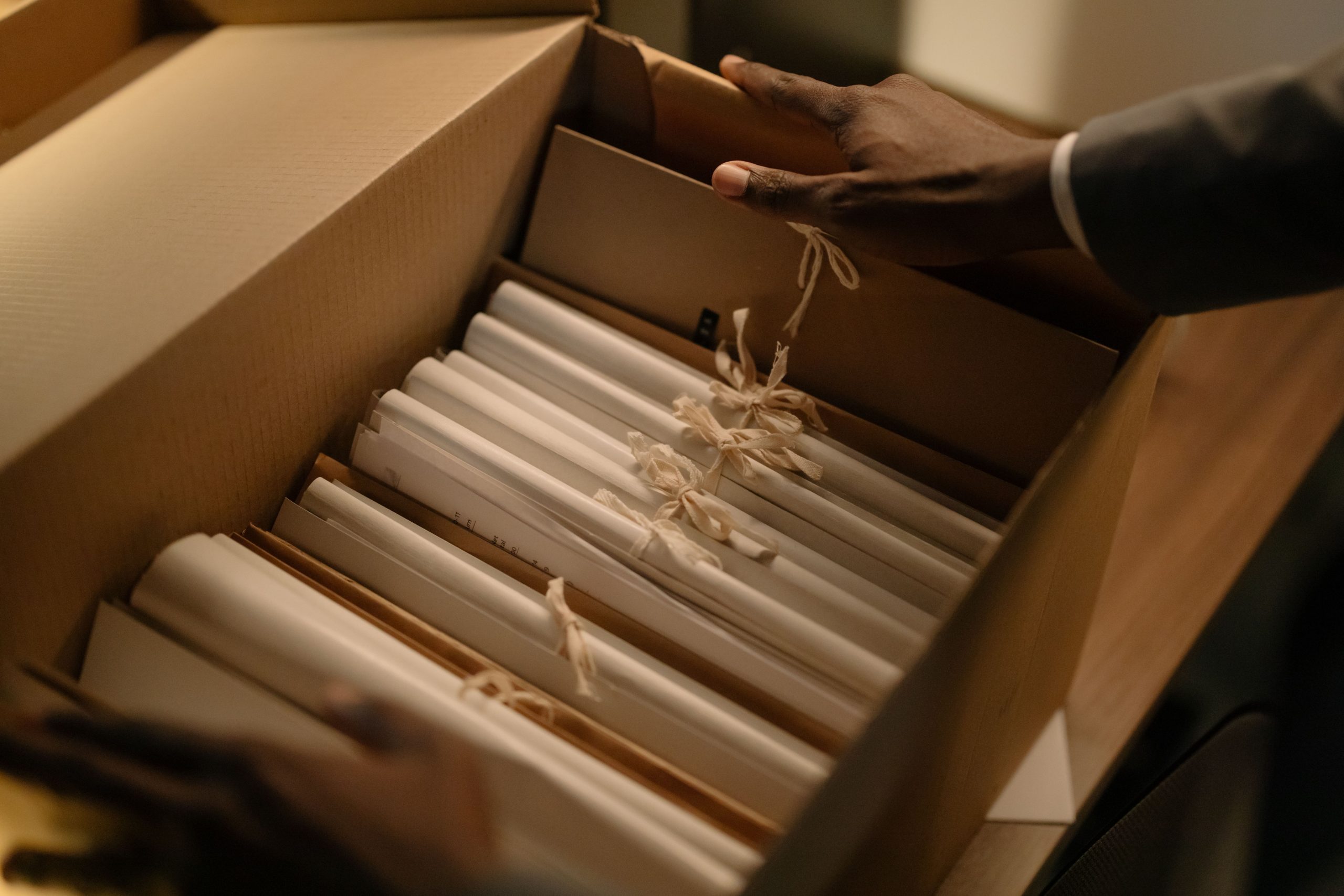 Hands organizing files in a box, symbolizing investigation and research
